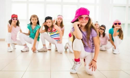 Des jeunes filles posent aun genoux au sol, elles ont des casquettes de couleurs différentes