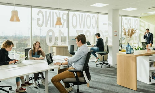 Un espace de coworking très clair avec des personnes assises à des bureaux