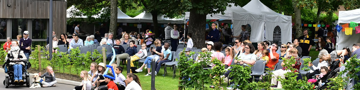 Fete du parc Valmy  des personnes sont assises et regarde un spectacle