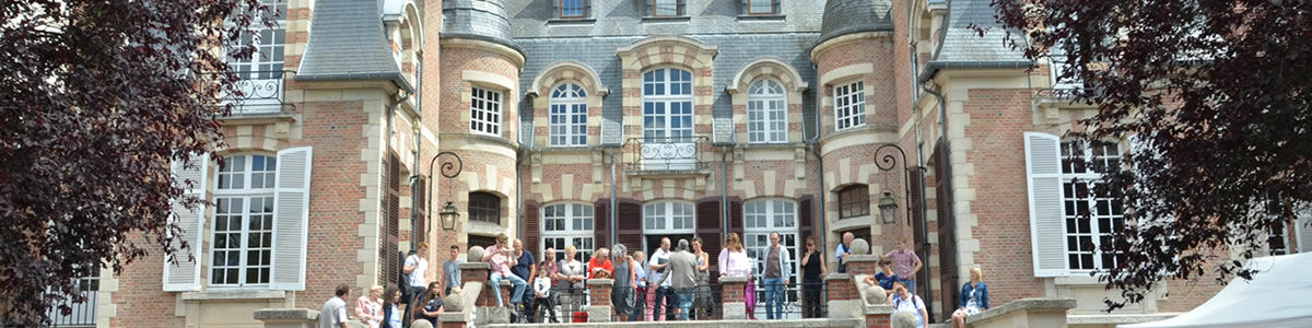 Des personnes jouent des instruments de musique sur les marches du conservatoire un ancien hôtel particulier au toit d'ardoises